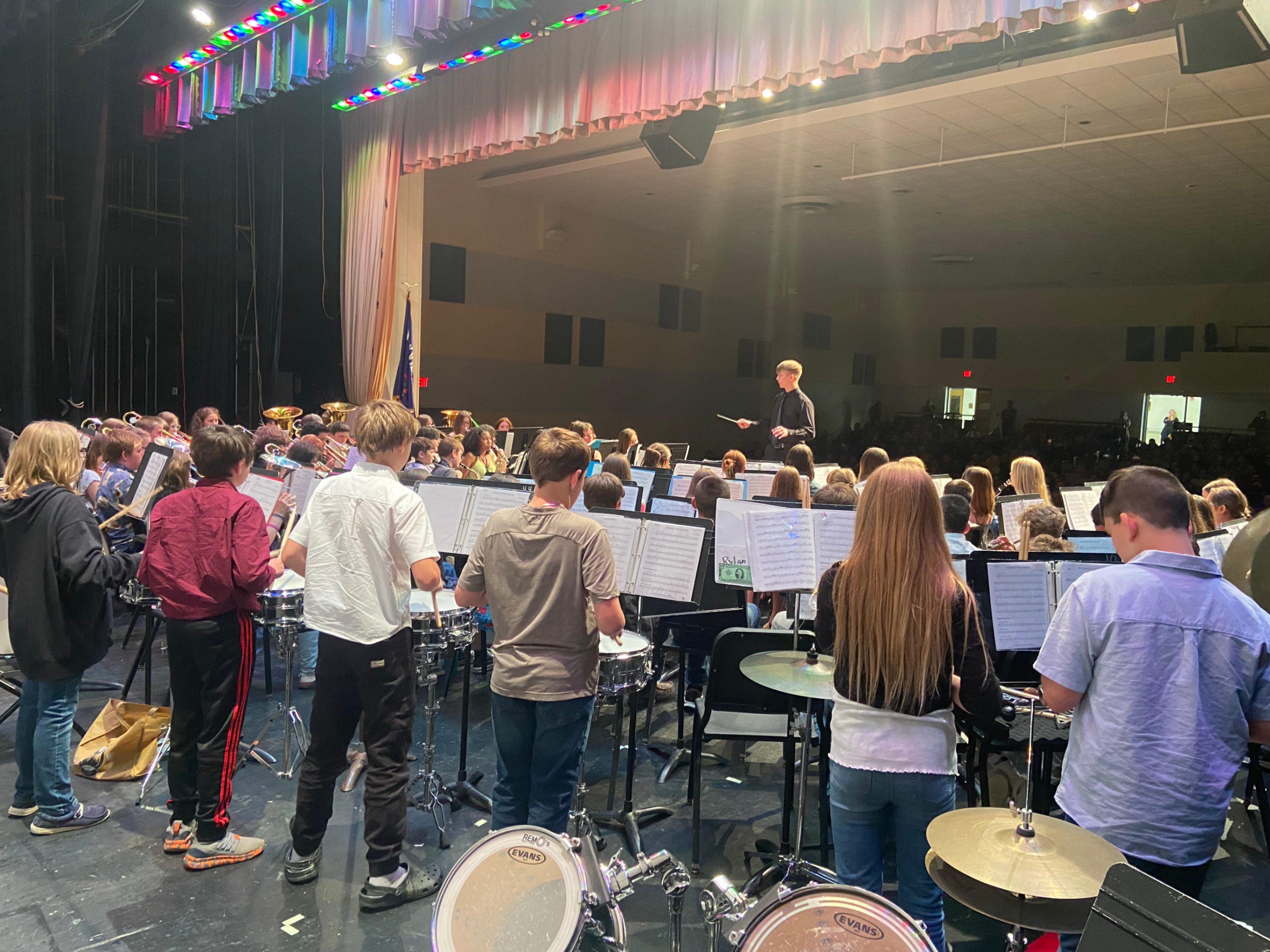 Max D'Argy conducts elementary band students was they perform on stage in the high school auditorium.